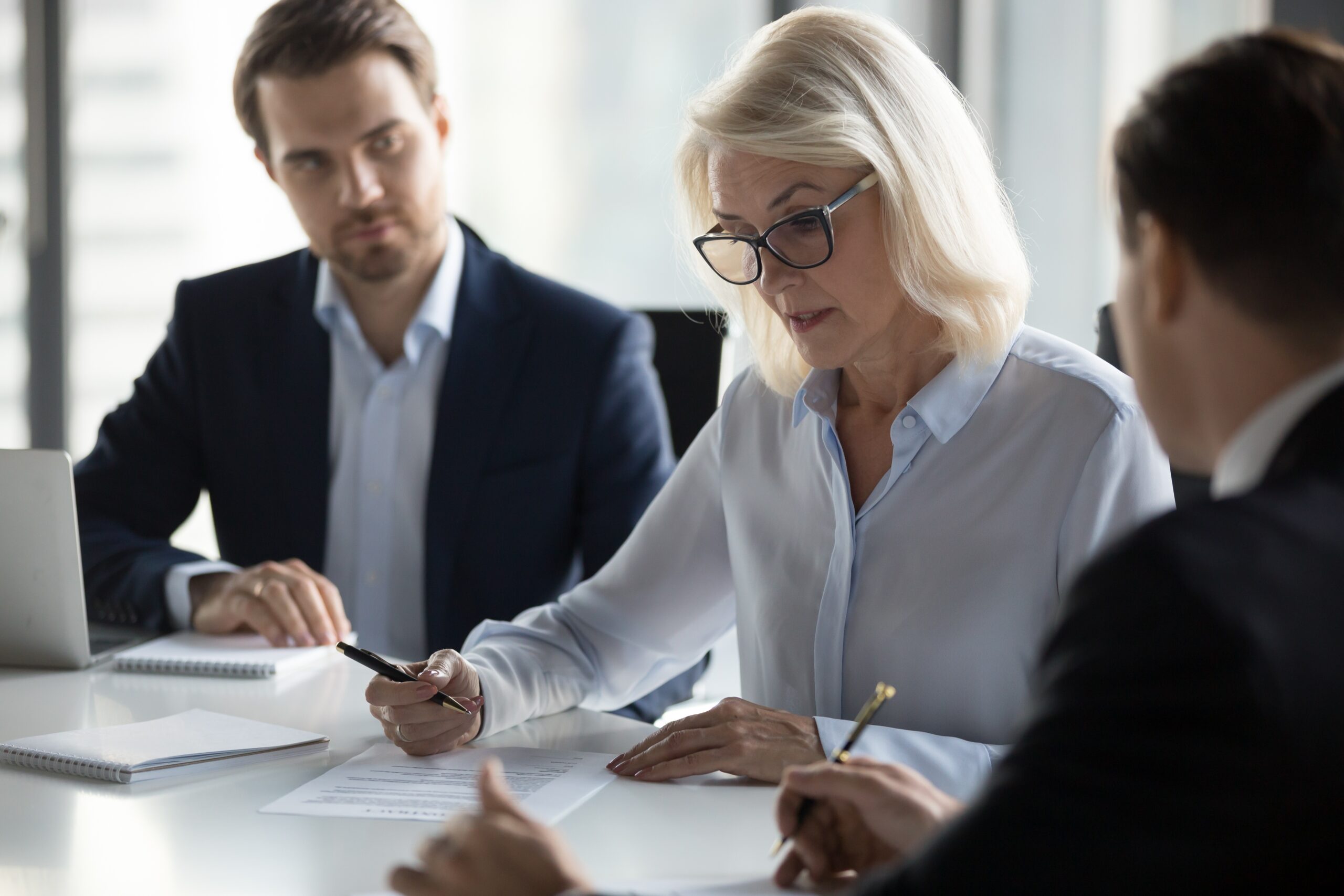 Concentrated aged businesswoman checking agreement before signin